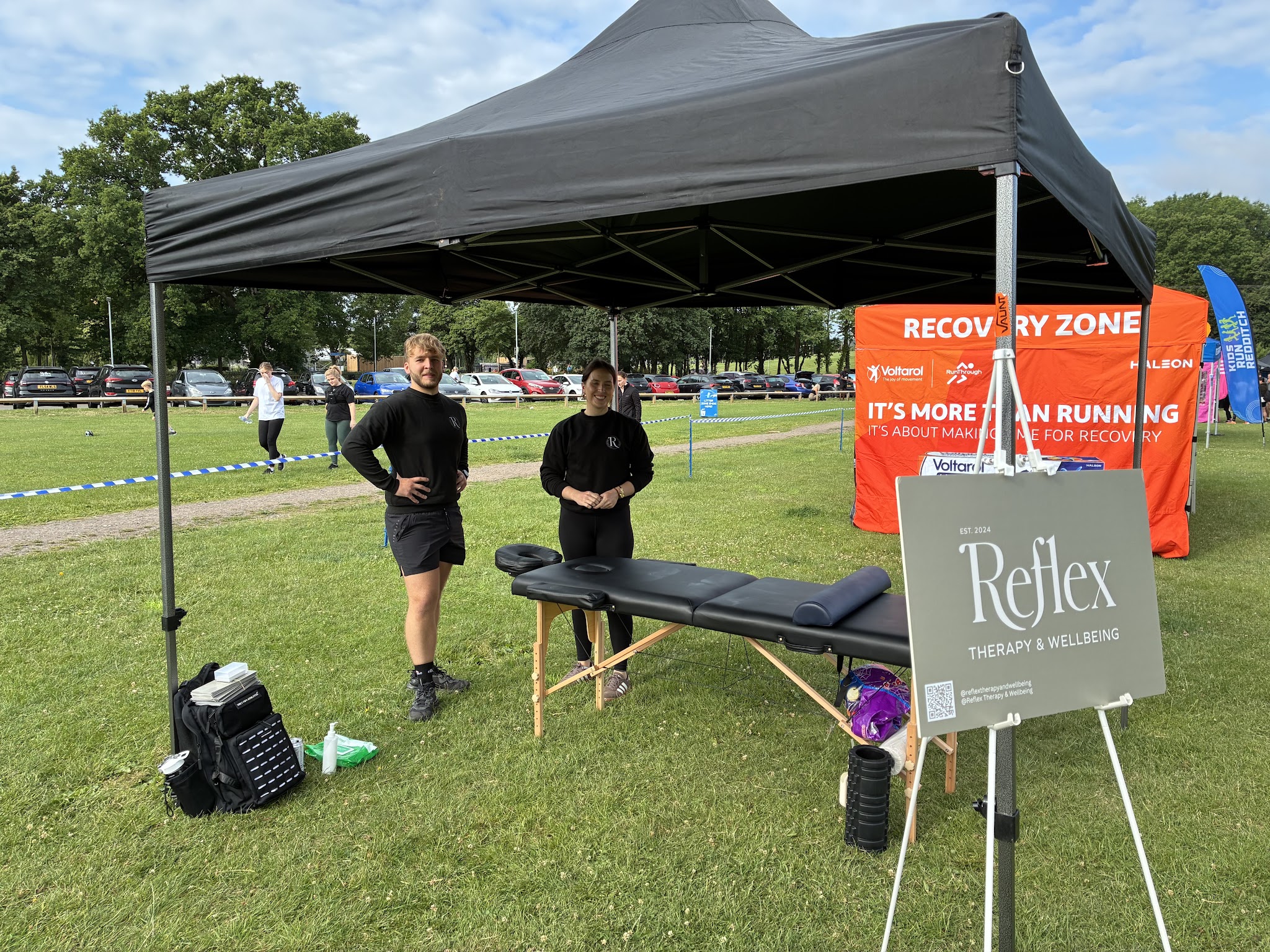 The Reflex massage stand at a running event in Redditch, with the Reflex Therapy & Wellbeing sign