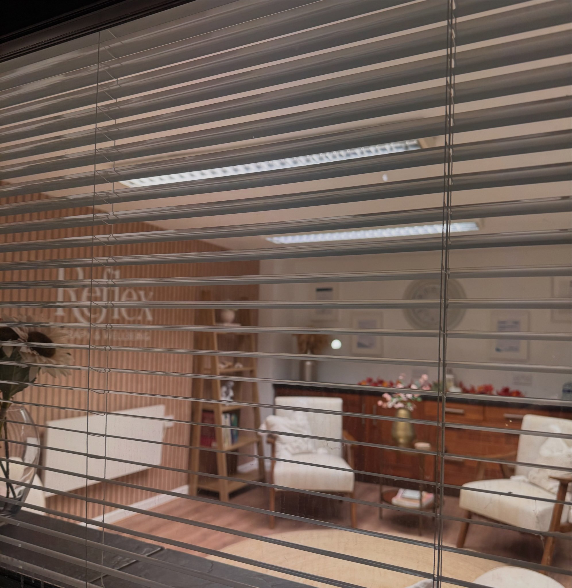 The new seating area and Reflex wall lettering, seen through the window blinds at Top Barn